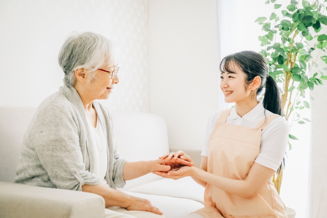 訪問介護する女性と高齢者(笑顔)